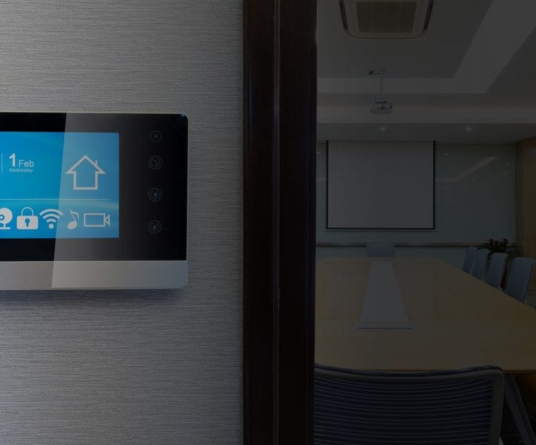 Smart thermostat displaying a home icon on a wall.