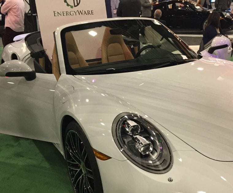 Sleek white convertible sports car on display at an auto show.