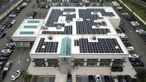 A woman with red hair working on a laptop in a bright, modern room.