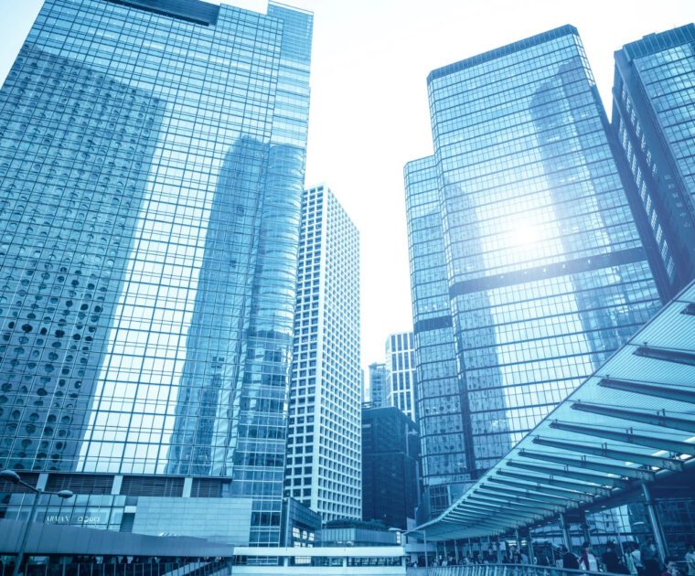 Modern glass skyscrapers reflecting sunlight in a cityscape.