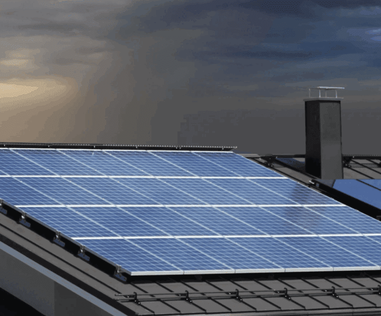 Solar panels installed on a rooftop under a cloudy sky.
