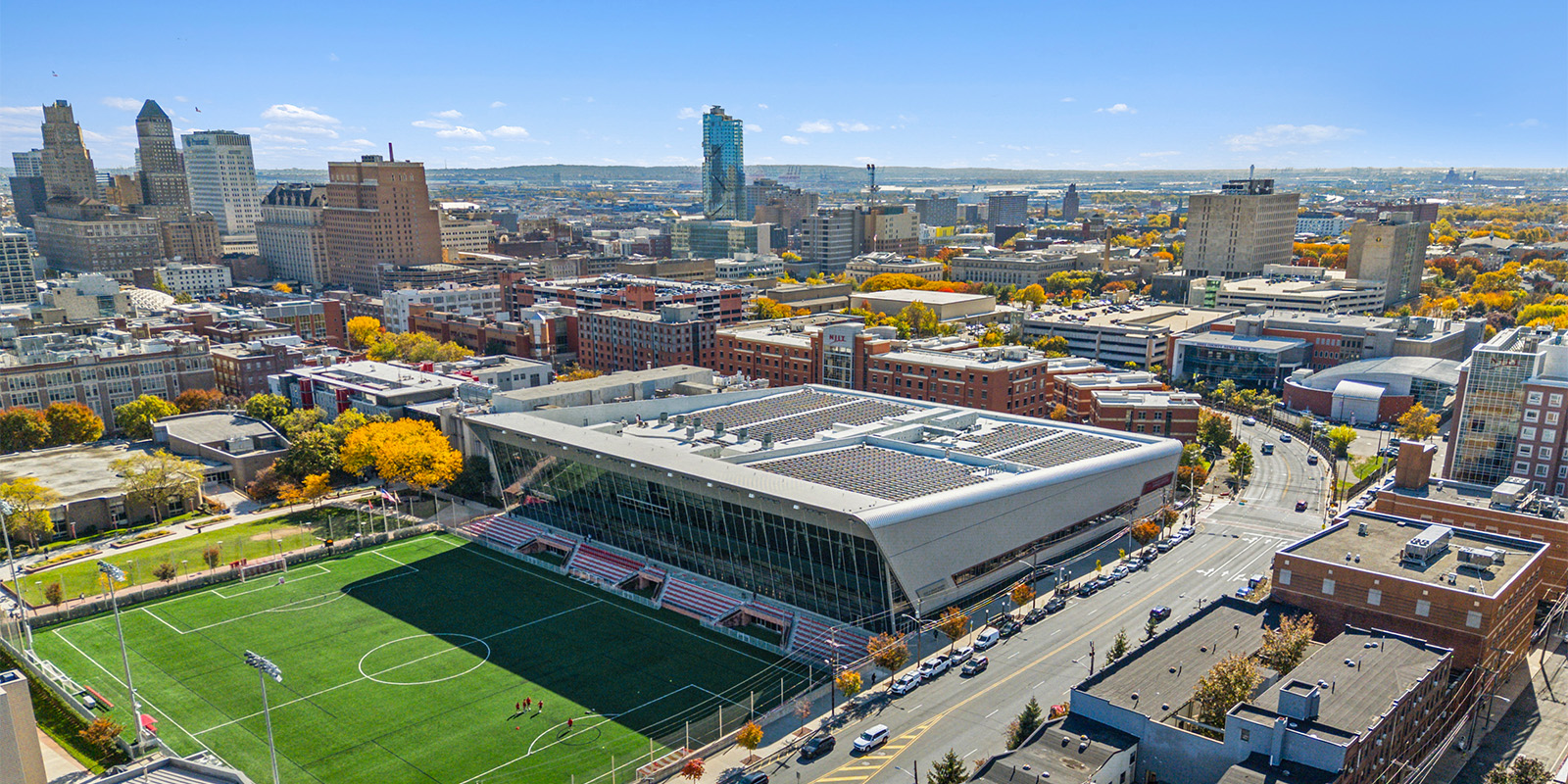 Aerial view of a stadium and surrounding cityscape on a clear day.