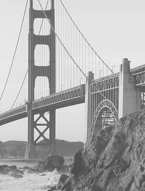 Black and white photo of the Golden Gate Bridge with rocky foreground.